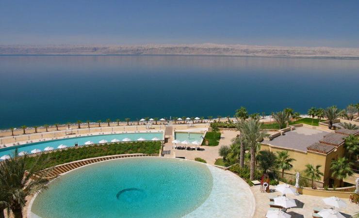  Bazén, pláž a Mŕtve more pri hoteli Kempinski Ishtar Dead Sea. Jordánsko