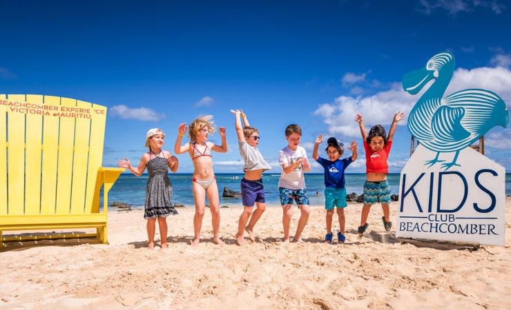 6 detí na pláži pri mori pred hotelom Victoria Beachcomber. Maurícius