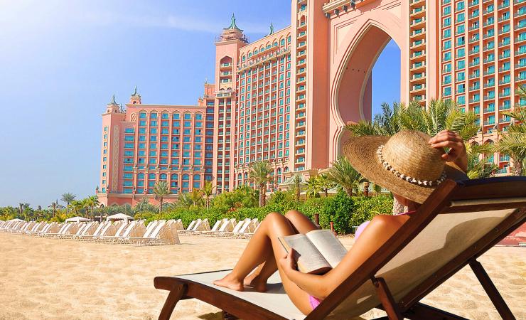 Žena na pláži na lehátku v hoteli Atlantis, The Palm