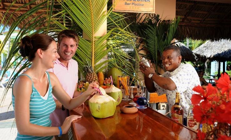 Párik na bare pije kokosovú šťavu