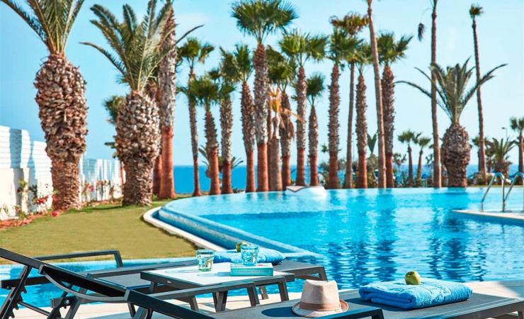 Bazén s lehátkami, palmi a výhľad na more v hoteli Atlantica Mare Village *****