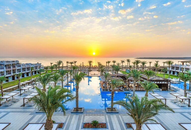Krásna pláž ožiarená slnkom, bazén a budovy hotela Iberotel Costa Mares. Egypt